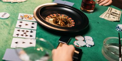 cropped image of girls playing roulette at poker table in casino