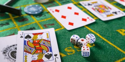 Gambling board game.Cards, chips, roulette.Gaming flat lay. Close-up of a card for playing poker on a gaming table in a casino against a background of chips. Background for the gaming business.